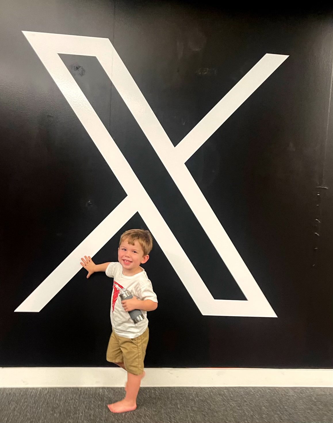 Elon Musk’s son poses with company’s new logo